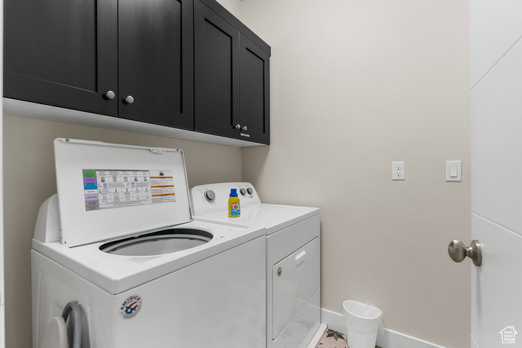 Laundry area with independent washer and dryer, cabinet space, and baseboards