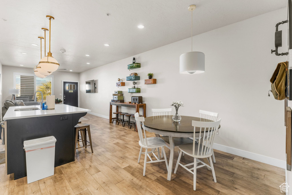 Dining room with recessed lighting, baseboards, and light wood-style floors