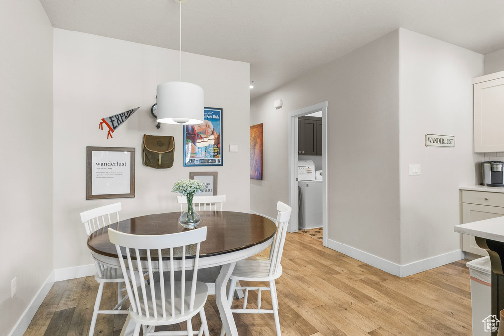 Dining room featuring light wood finished floors, baseboards, and washer and dryer