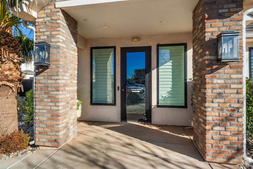 Doorway to property featuring brick siding and stucco siding