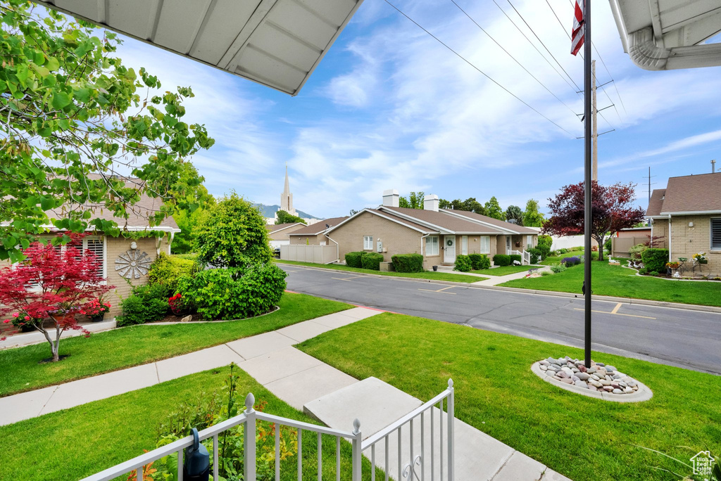 View of green lawn with a residential view
