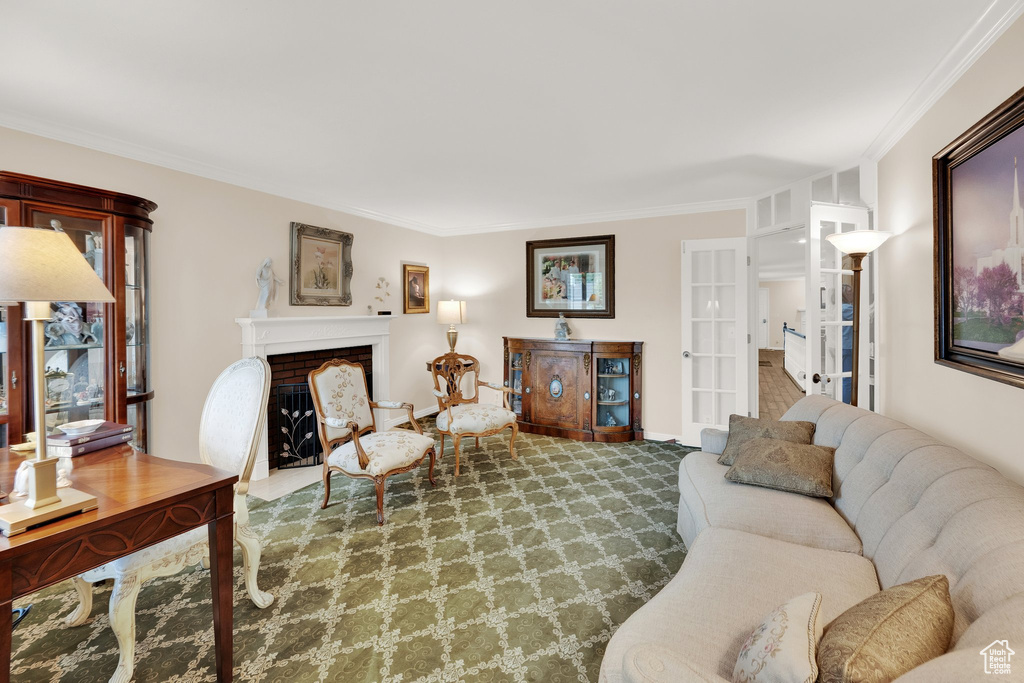 Carpeted living area featuring ornamental molding and a fireplace with flush hearth