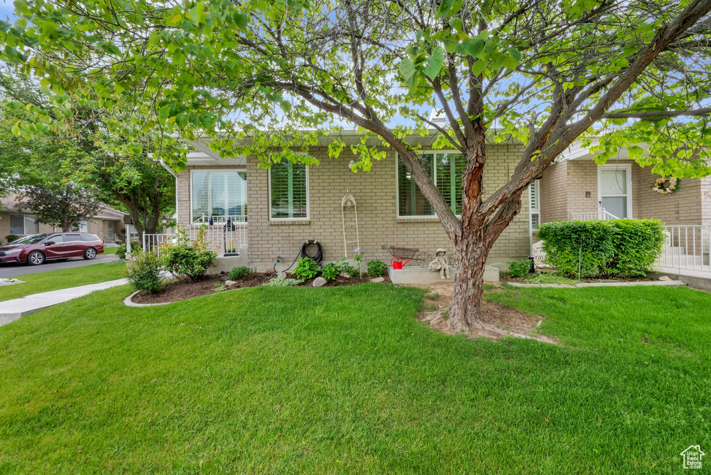 View of front of home featuring brick siding and a front yard