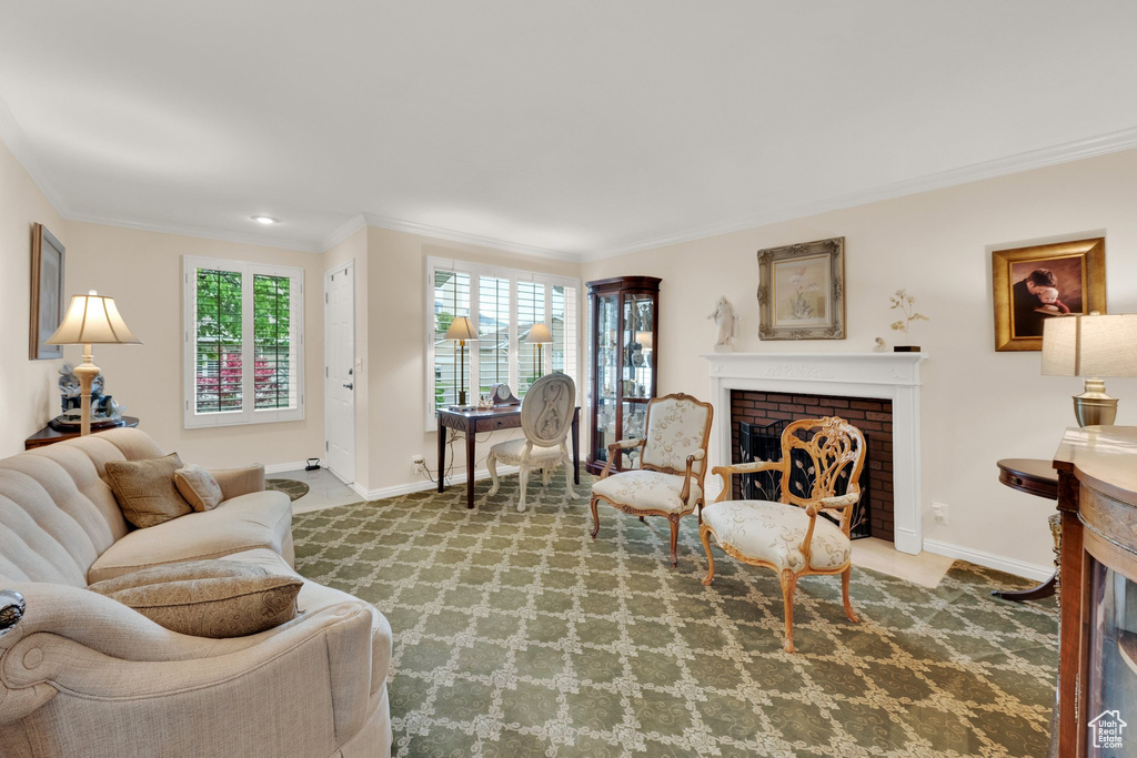 Living area with a brick fireplace, ornamental molding, and baseboards
