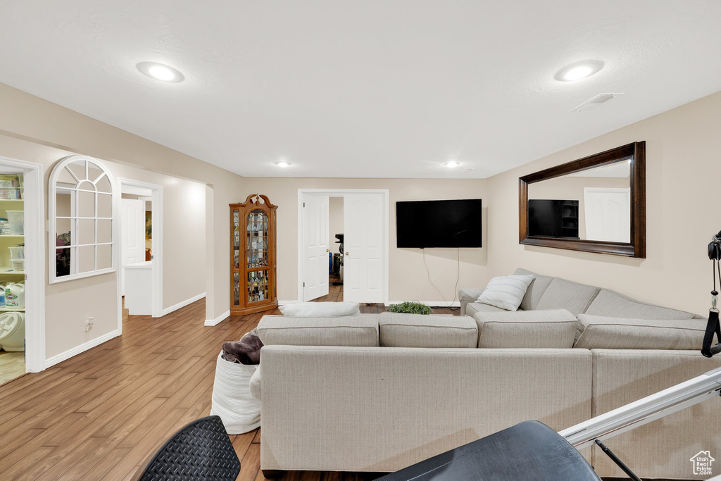 Living area with light wood-style flooring, baseboards, and recessed lighting