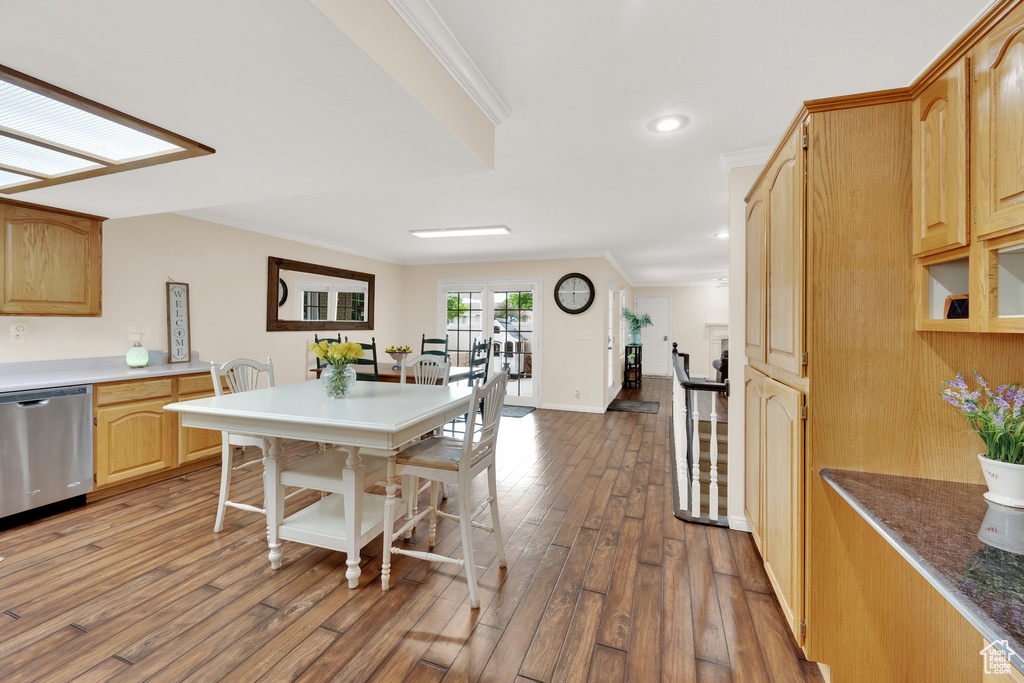 Kitchen featuring stainless steel dishwasher, wood finished floors, light brown cabinets, crown molding, and baseboards