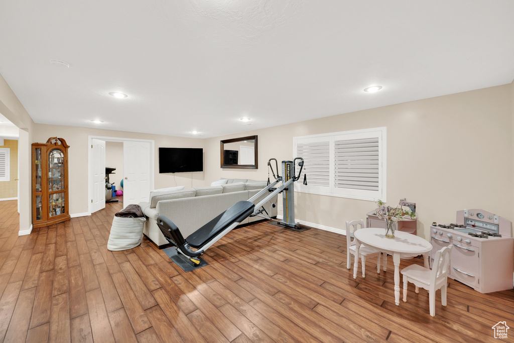 Exercise area featuring light wood finished floors, baseboards, and recessed lighting