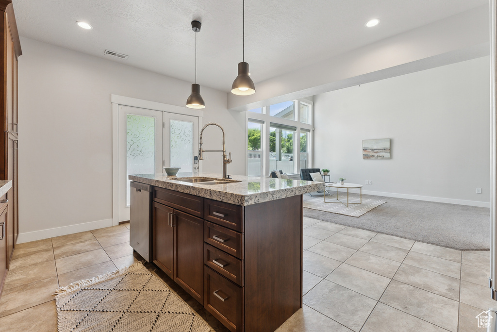 Kitchen with a sink, stainless steel dishwasher, light tile patterned flooring, dark brown cabinets, and recessed lighting