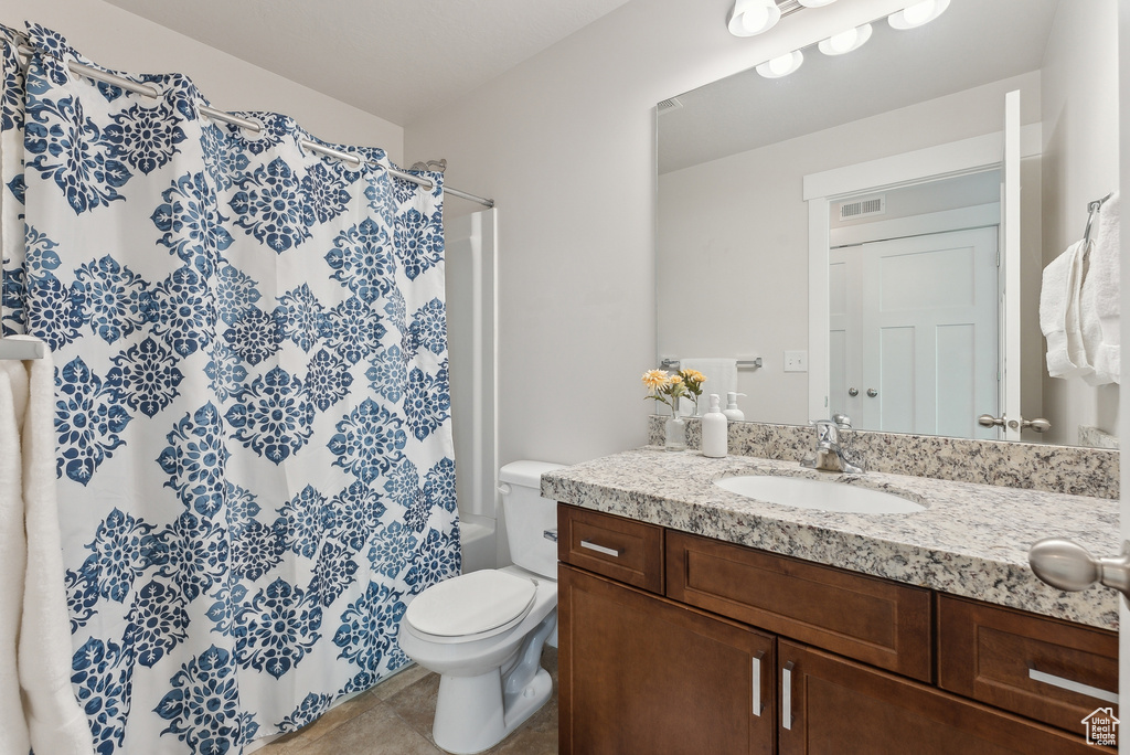 Full bath with vanity, toilet, tile patterned floors, and shower / bath combination with curtain