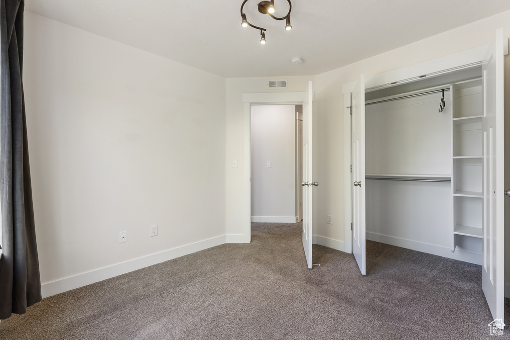 Unfurnished bedroom featuring carpet, a closet, and baseboards