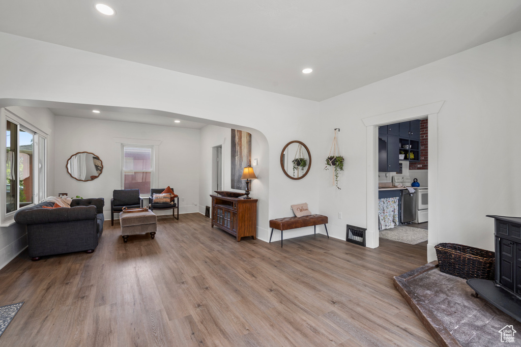 Living room featuring light wood-style flooring, arched walkways, recessed lighting, and baseboards