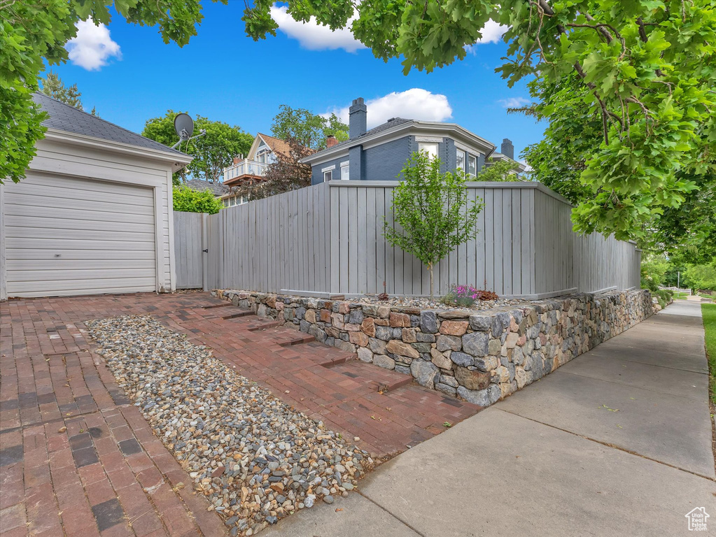 View of patio with a garage and a gate
