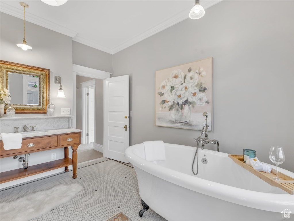 Full bath with ornamental molding, vanity, and a freestanding tub