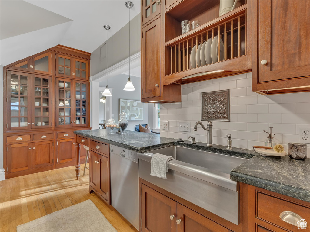 Kitchen with stainless steel dishwasher, brown cabinets, and light wood finished floors