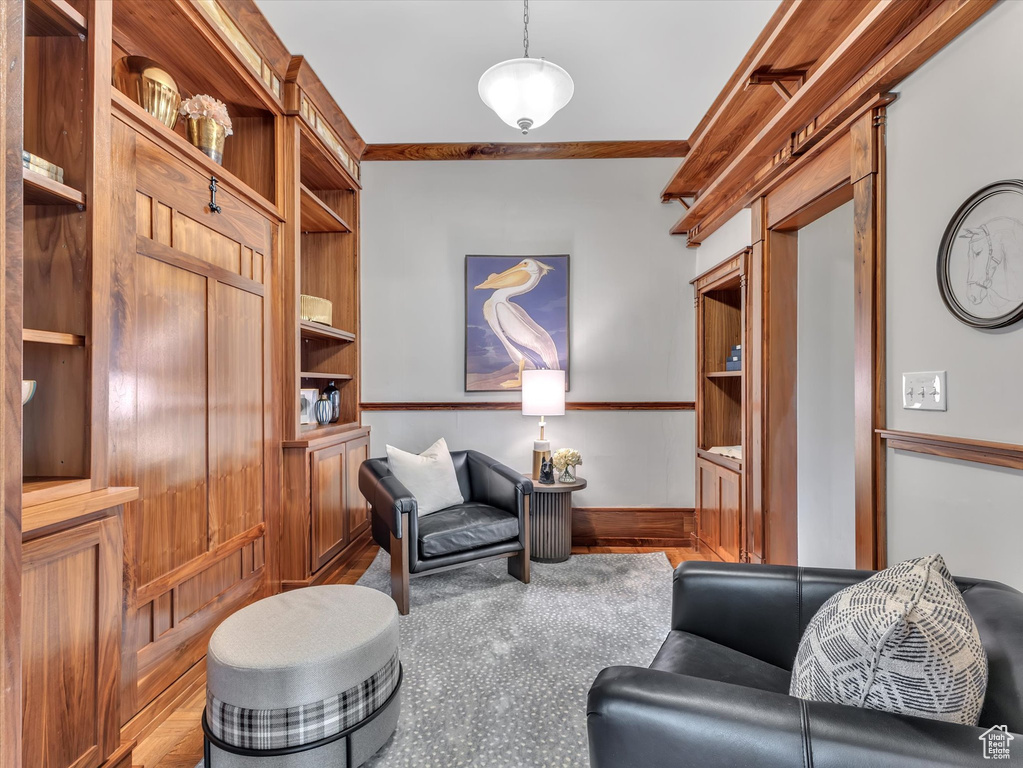 Sitting room featuring wood finished floors, ornamental molding, and built in features