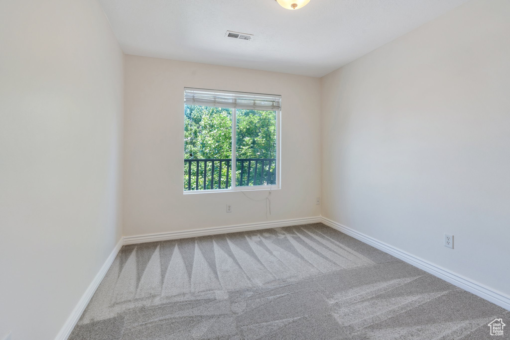 Carpeted spare room with baseboards