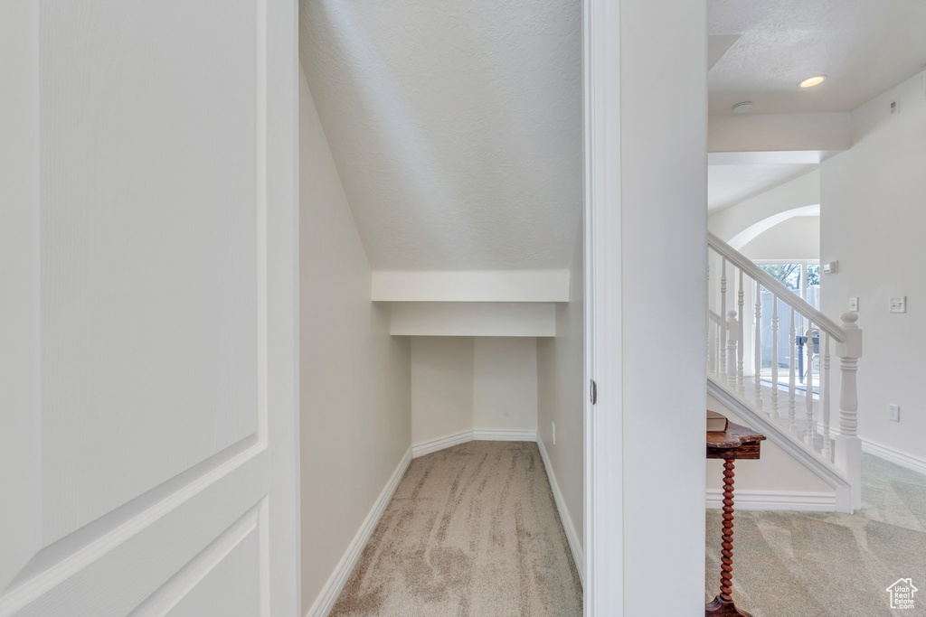 Hallway with carpet floors, arched walkways, stairs, and baseboards