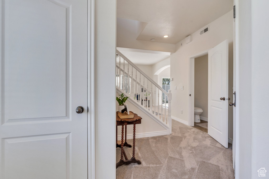 Entryway featuring carpet floors, arched walkways, stairs, recessed lighting, and baseboards