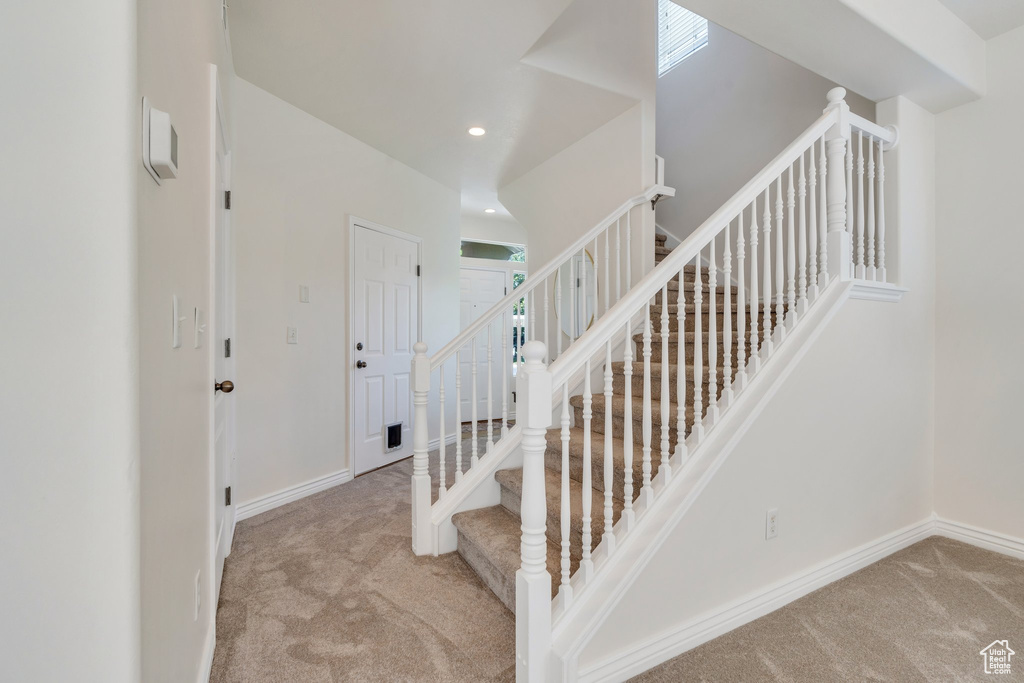 Stairway featuring carpet floors, baseboards, plenty of natural light, and recessed lighting
