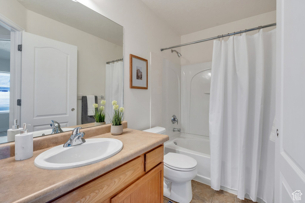 Full bath with vanity, toilet, tile patterned floors, and shower / tub combo with curtain
