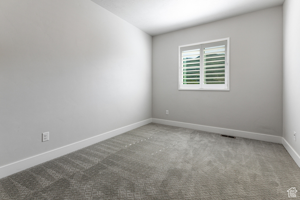 Carpeted empty room featuring baseboards