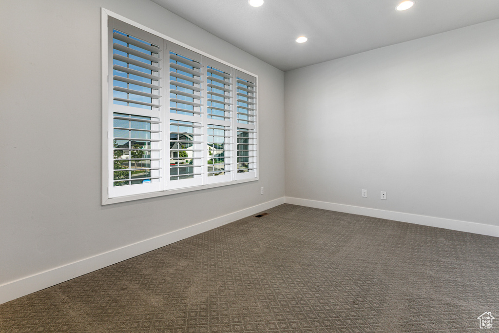 Unfurnished room with recessed lighting, dark carpet, and baseboards