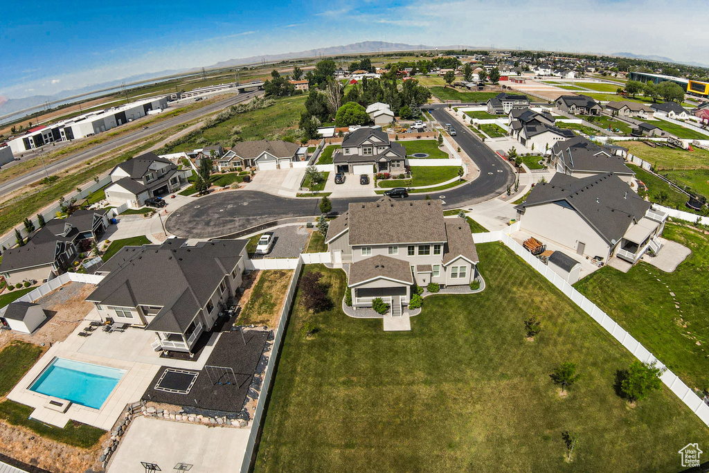 Aerial overview of property\'s location with nearby suburban area, a mountain backdrop, and a pool