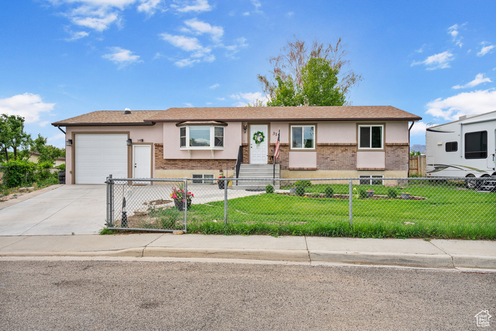View of front of home with concrete driveway, a garage, brick siding, and stucco siding