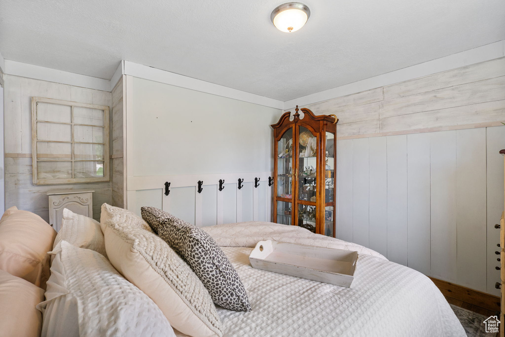 Bedroom with wooden walls and wood finished floors
