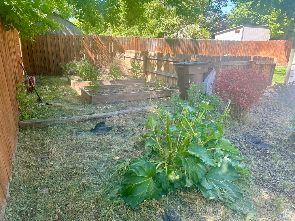 Fenced backyard featuring a garden