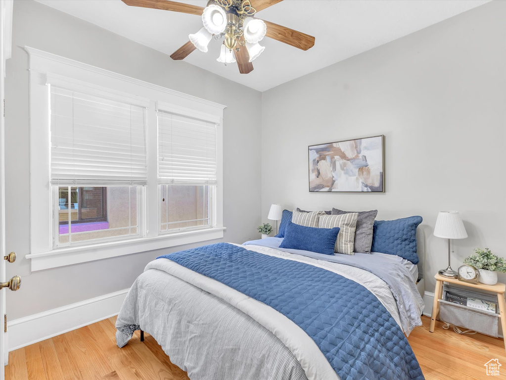 Bedroom with wood finished floors, a ceiling fan, and baseboards