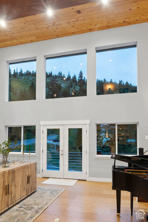 Sitting room with wooden ceiling, baseboards, a high ceiling, french doors, and wood finished floors