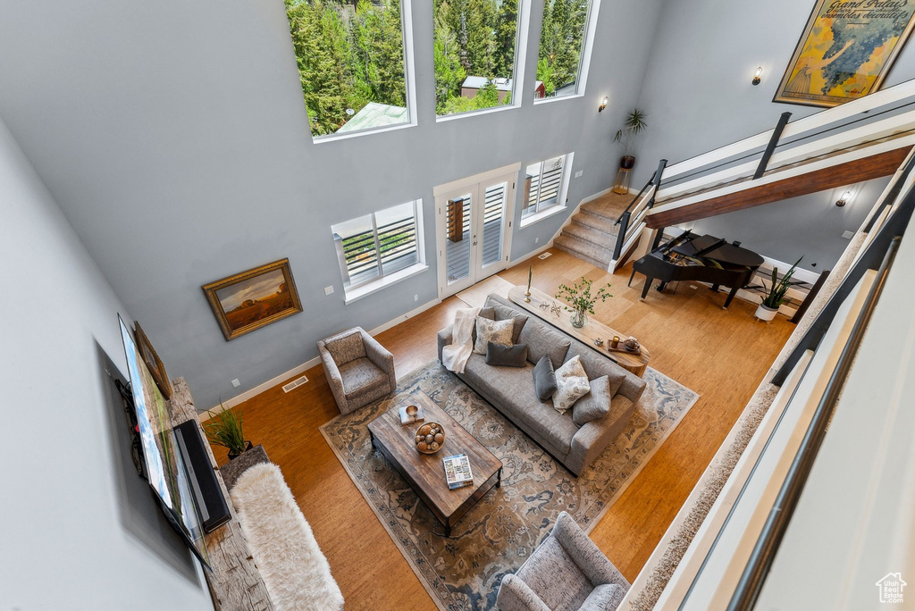 Living room with wood finished floors, baseboards, and a high ceiling