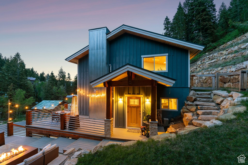 Contemporary home featuring an outdoor fire pit, board and batten siding, and a chimney