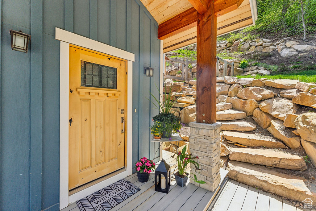Doorway to property featuring board and batten siding and covered porch