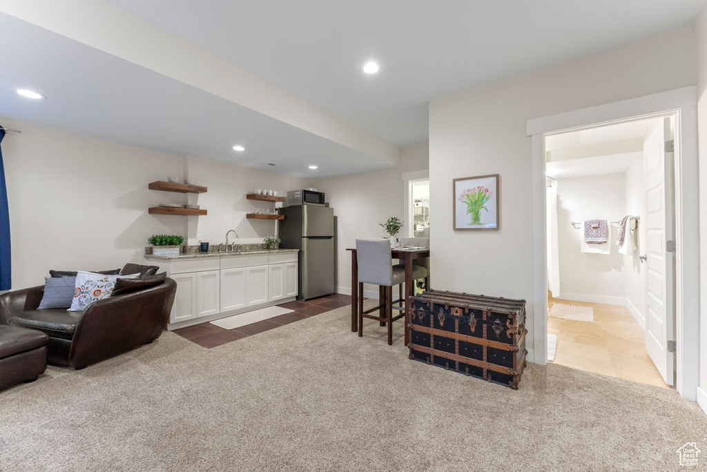 Living room featuring carpet floors, wet bar, recessed lighting, and tile patterned flooring