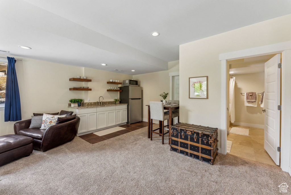 Living room featuring bar with sink, dark colored carpet, recessed lighting, and dark tile patterned flooring