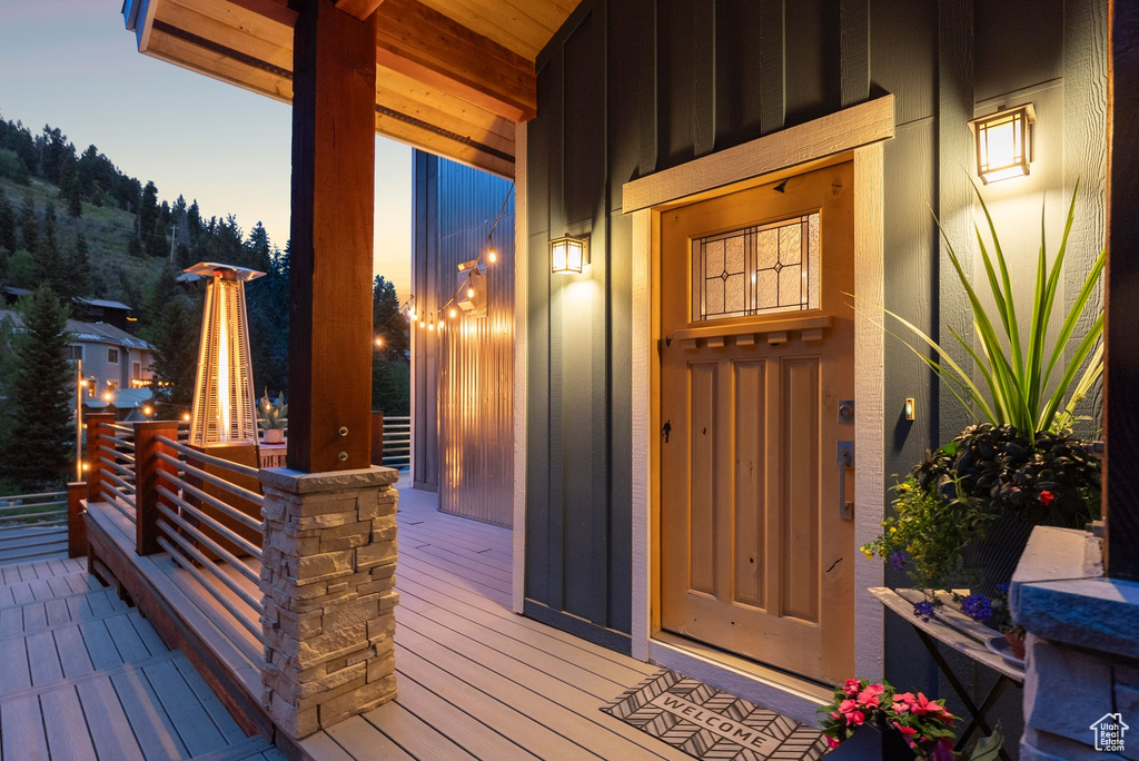 Exterior entry at dusk with board and batten siding and covered porch