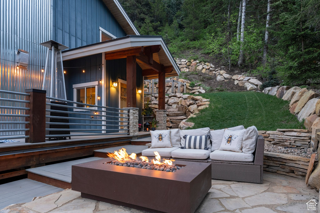 View of patio / terrace with an outdoor living space with a fire pit and a wooded view