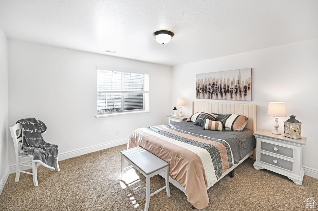 Bedroom featuring carpet and baseboards