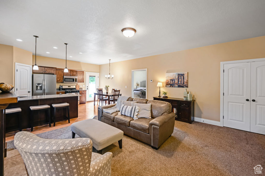 Living room featuring recessed lighting, a chandelier, and baseboards