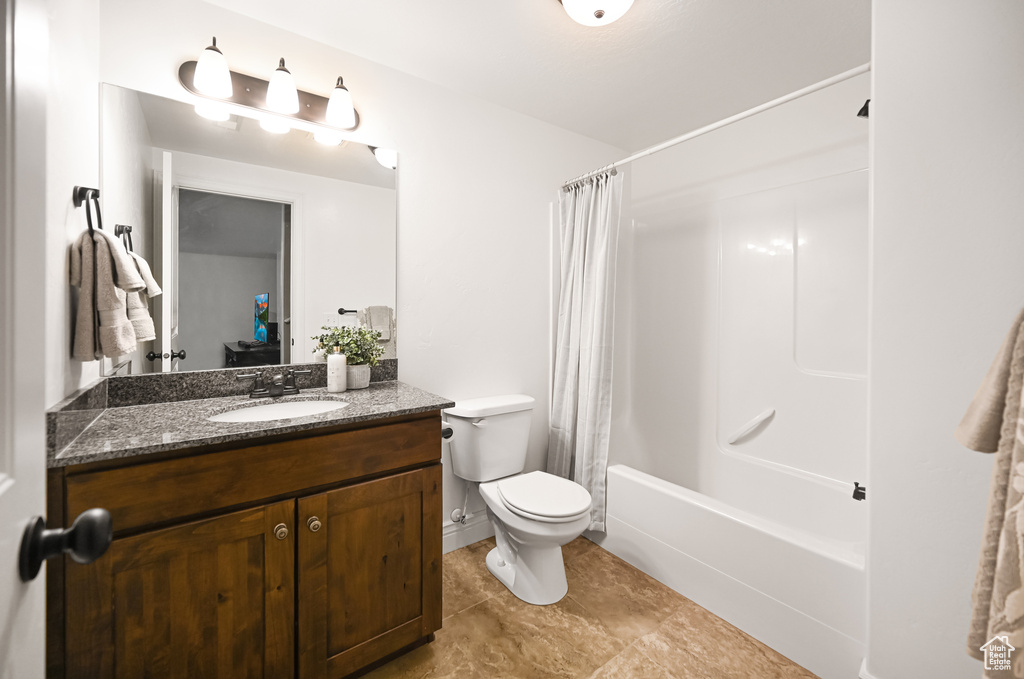 Full bath with vanity, toilet, shower / bath combination with curtain, and tile patterned floors