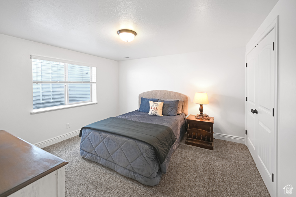 Bedroom featuring carpet flooring and baseboards