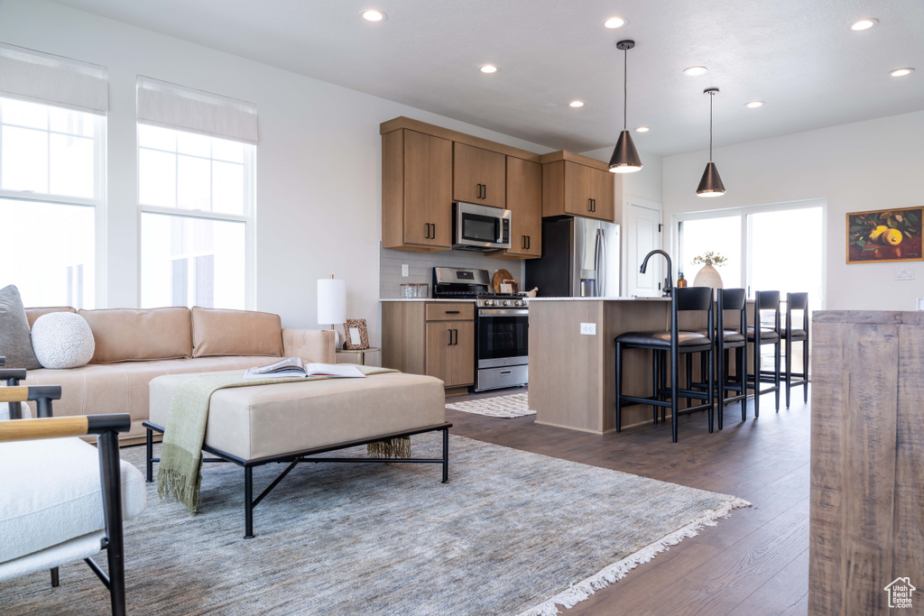 Living area featuring plenty of natural light, recessed lighting, and dark wood-style floors