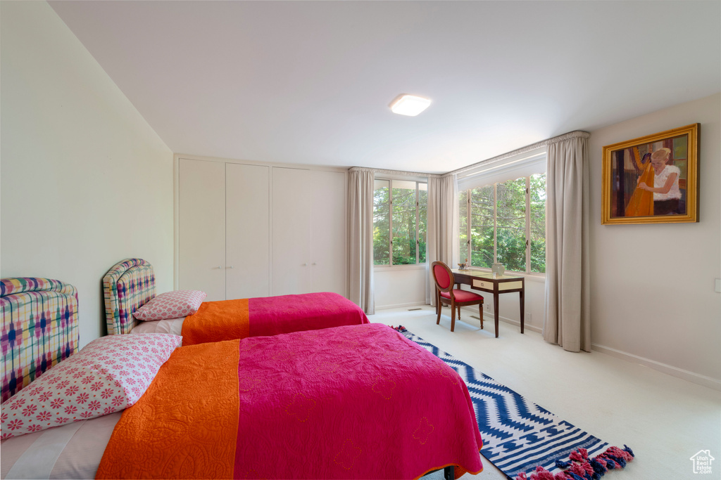 Bedroom with carpet, baseboards, and a closet