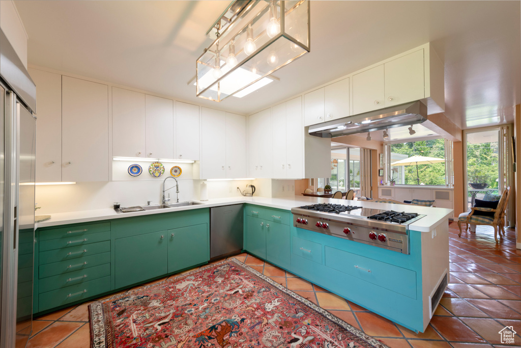 Kitchen with a sink, stainless steel gas stovetop, light tile patterned floors, and light countertops