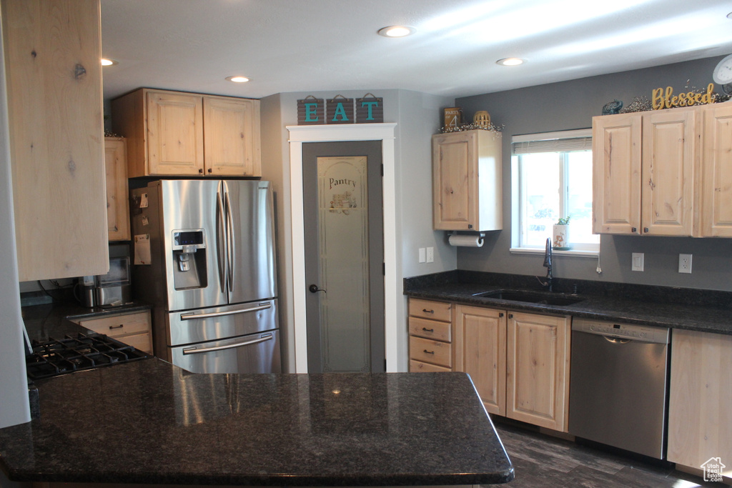 Kitchen with stainless steel appliances, a sink, light brown cabinetry, a peninsula, and recessed lighting