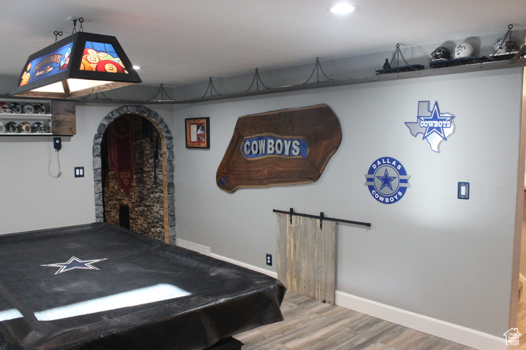 Rec room with wood finished floors, baseboards, recessed lighting, a barn door, and pool table