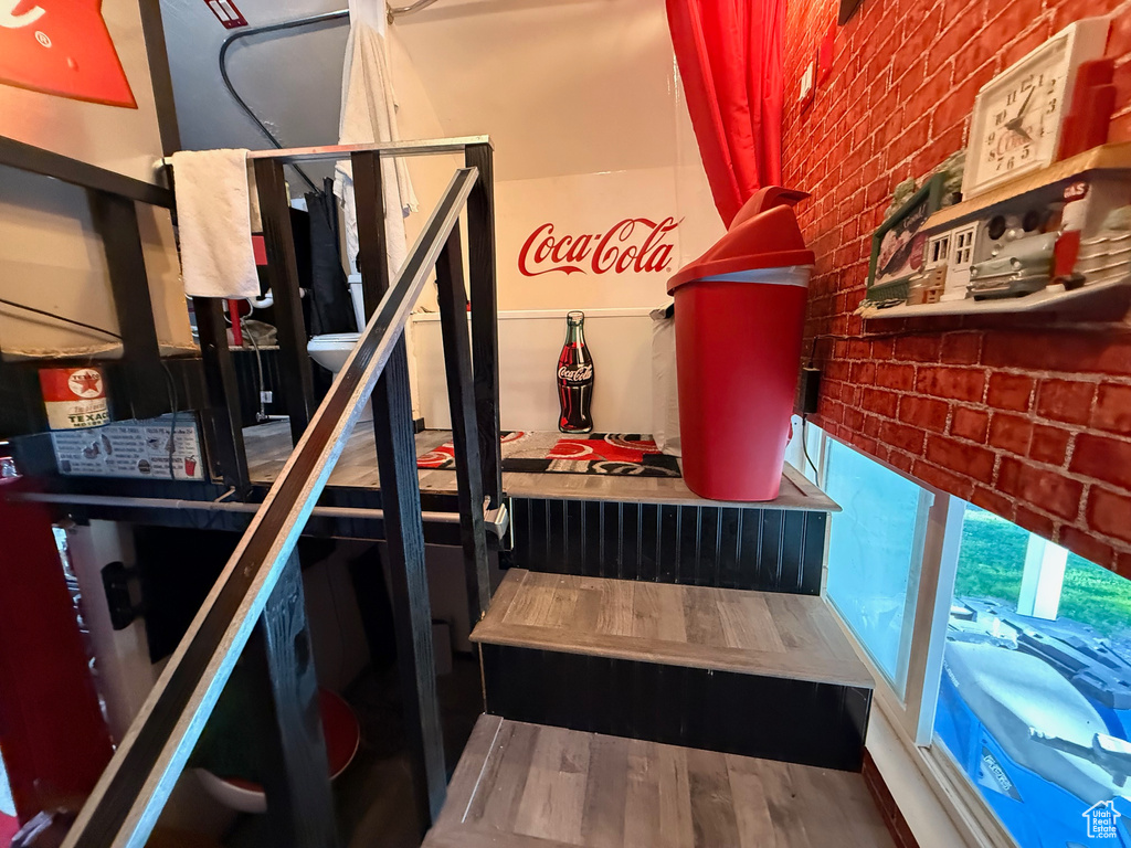 Staircase featuring brick wall