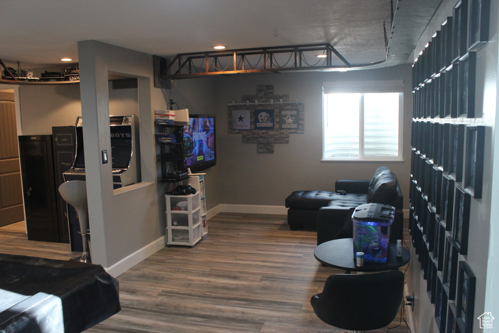 Living room with baseboards, wood finished floors, and recessed lighting